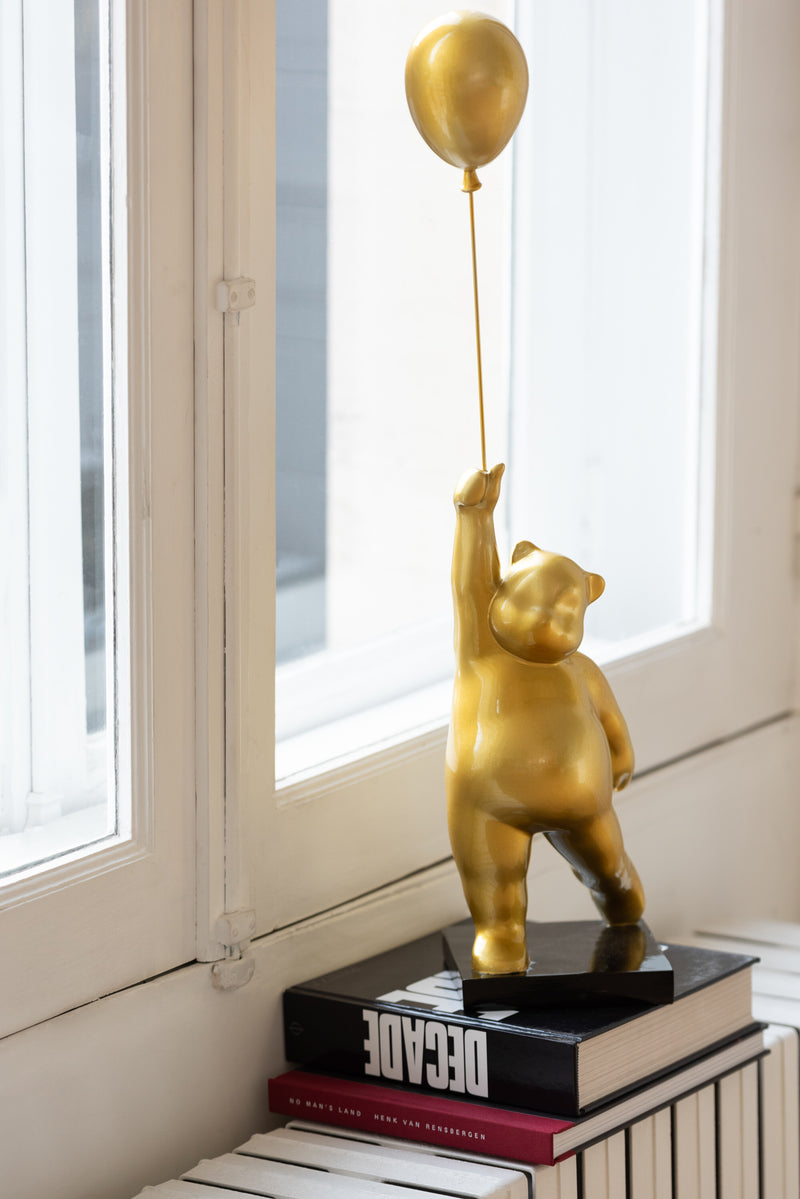 Bear on ball made of shiny polyresin in gold