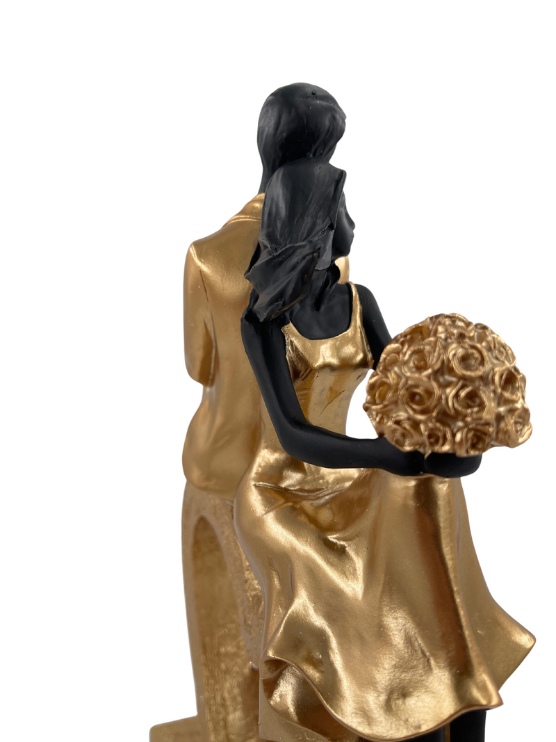 Elegant sculpture of a seated couple in heart shape, black and gold