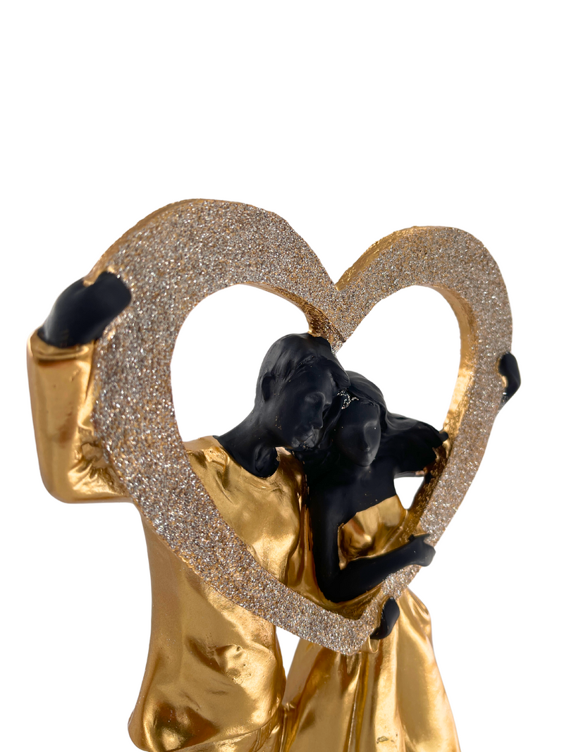 Elegant sculpture of a couple in black and gold with heart shiny