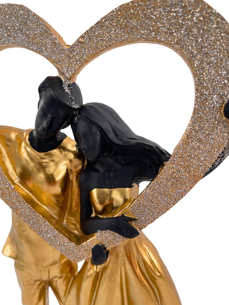 Elegant sculpture of a couple in black and gold with heart shiny