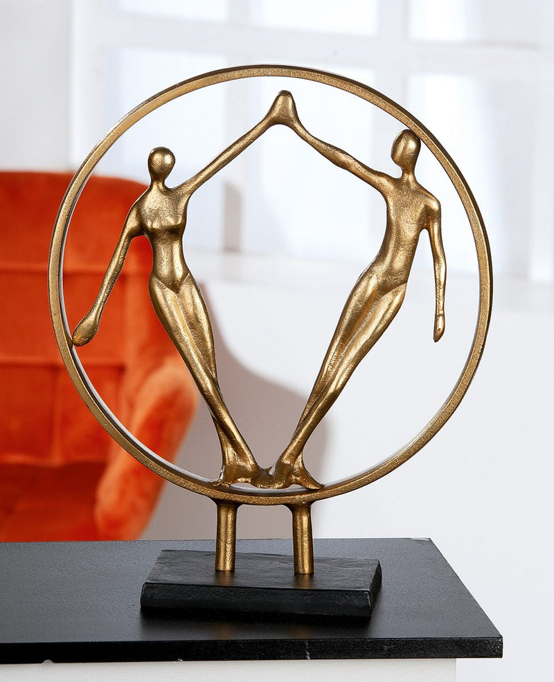Hand in Hand - A gold colored decorative sculpture on a black metal base